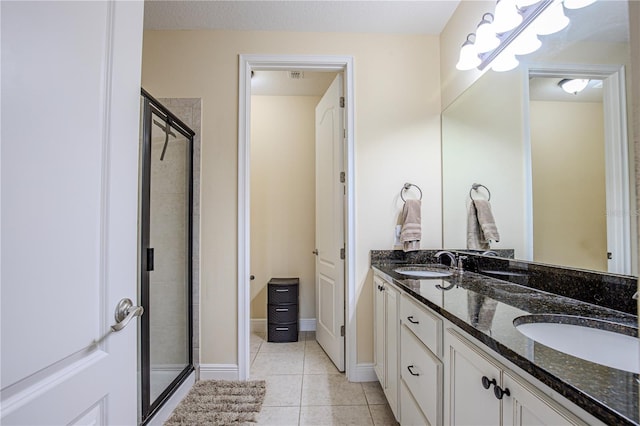 bathroom with tile patterned flooring, vanity, and a shower with door