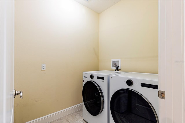 clothes washing area with independent washer and dryer and light tile patterned floors