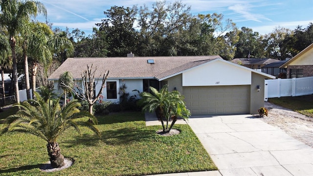 ranch-style home with a garage and a front lawn