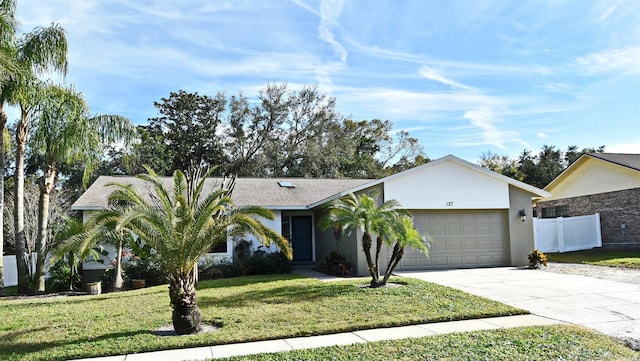 single story home featuring a garage and a front yard