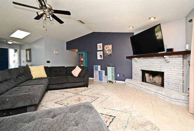 tiled living room with lofted ceiling, a brick fireplace, a textured ceiling, and ceiling fan