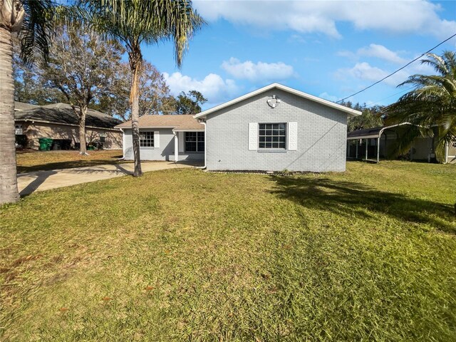 back of property featuring a yard and a carport