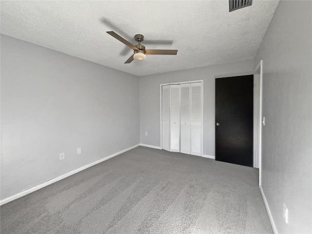 unfurnished bedroom with ceiling fan, carpet floors, a closet, and a textured ceiling