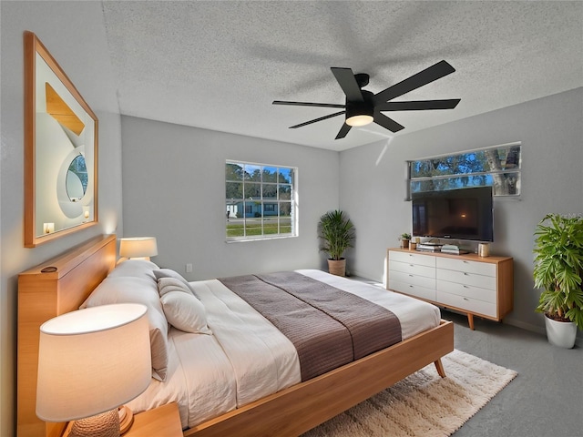 bedroom with a textured ceiling, ceiling fan, and carpet flooring