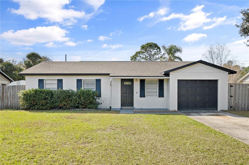 ranch-style home featuring a garage and a front lawn