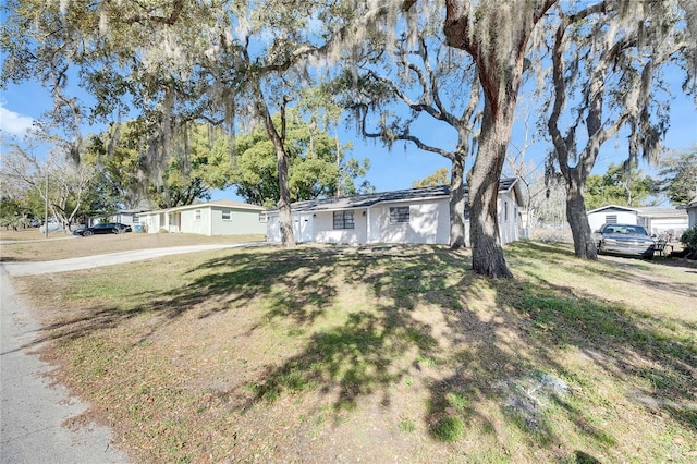 single story home featuring a front lawn