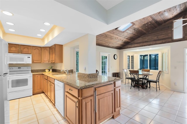 kitchen with sink, white appliances, light stone countertops, light tile patterned flooring, and kitchen peninsula