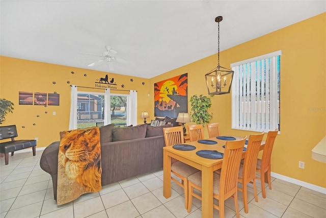 tiled dining space featuring ceiling fan with notable chandelier