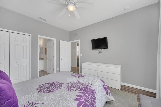 bedroom with hardwood / wood-style flooring, ceiling fan, connected bathroom, and a closet