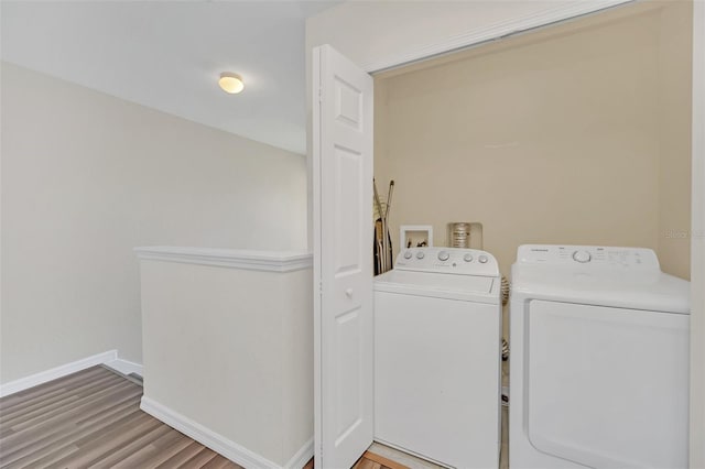 laundry area with hardwood / wood-style flooring and washing machine and dryer
