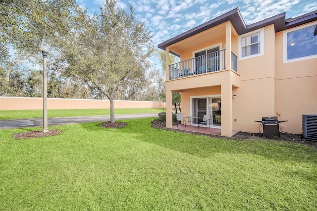 back of property featuring central AC and a lawn