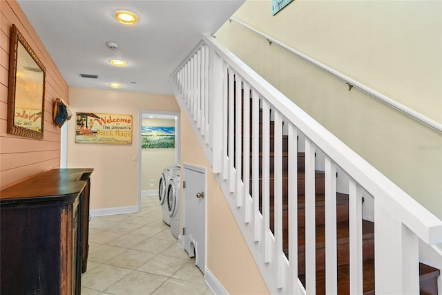 stairway featuring tile patterned floors, wooden walls, and separate washer and dryer