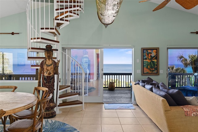 tiled living room featuring a water view and high vaulted ceiling