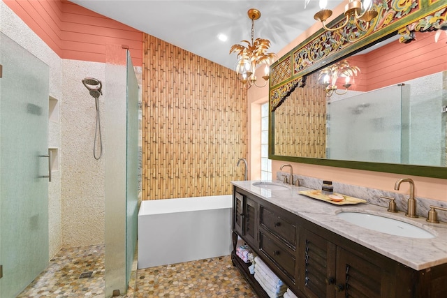 bathroom featuring a chandelier, vanity, separate shower and tub, and wood walls