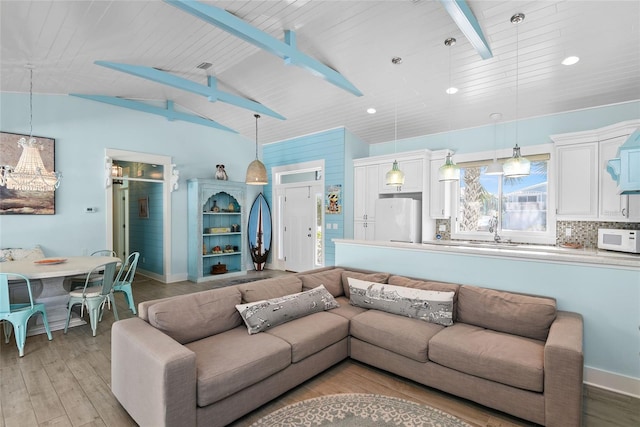 living room featuring vaulted ceiling with beams, wood ceiling, and light wood-type flooring