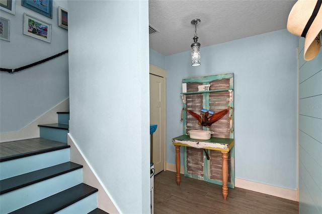 stairway with hardwood / wood-style flooring and a textured ceiling