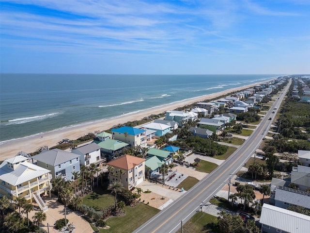 birds eye view of property featuring a water view and a beach view