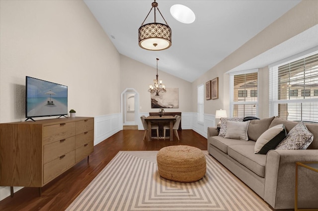 living room featuring lofted ceiling, dark wood-type flooring, and a chandelier