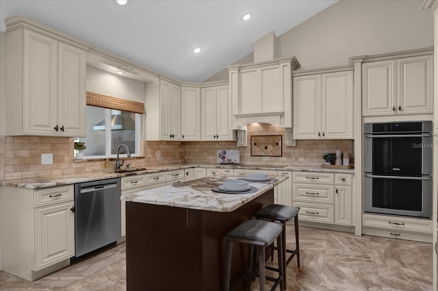 kitchen featuring sink, a breakfast bar, appliances with stainless steel finishes, a kitchen island, and vaulted ceiling