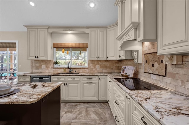 kitchen with tasteful backsplash, sink, light stone countertops, and black electric stovetop