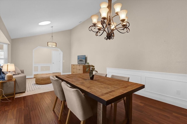 dining room with lofted ceiling, dark hardwood / wood-style floors, and an inviting chandelier