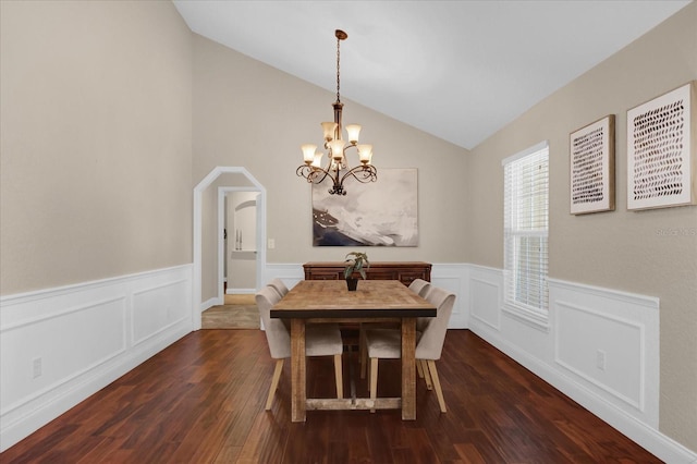 dining area featuring lofted ceiling, a notable chandelier, and dark hardwood / wood-style flooring