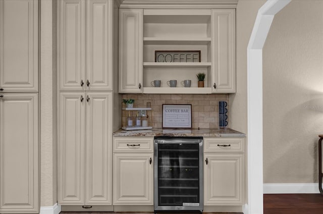 bar with wine cooler, decorative backsplash, dark hardwood / wood-style floors, and light stone counters