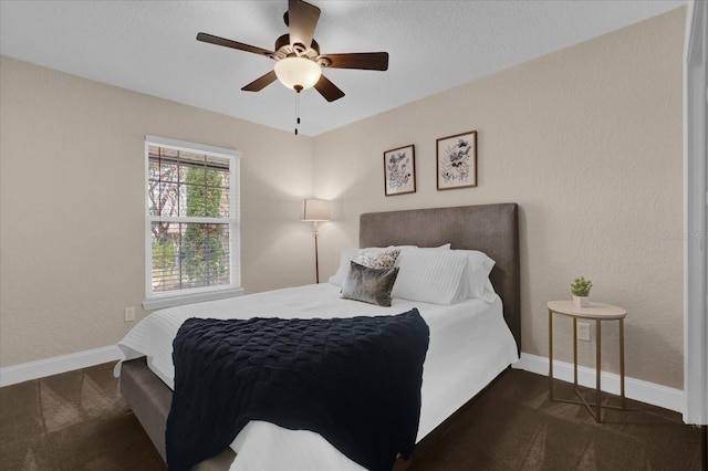 bedroom with ceiling fan and dark colored carpet