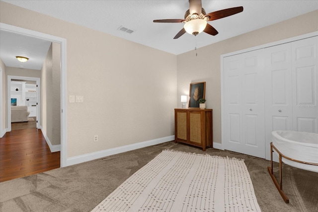 carpeted bedroom with ceiling fan and a closet