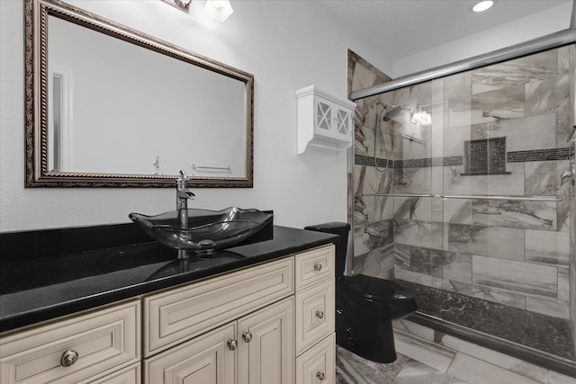 bathroom with a shower with door, vanity, and toilet