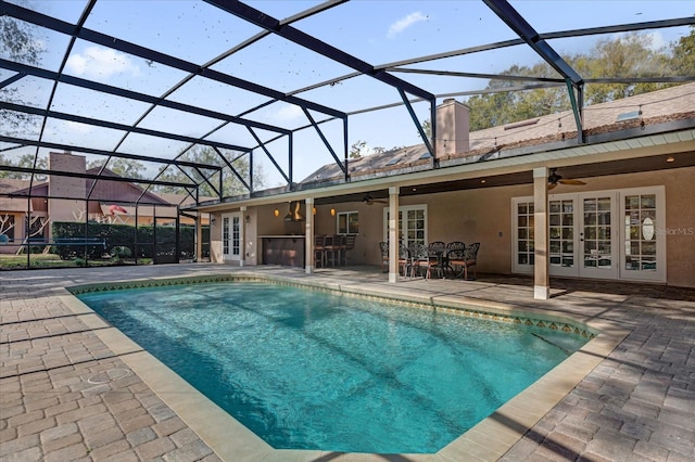 view of pool featuring french doors, a patio area, ceiling fan, and glass enclosure