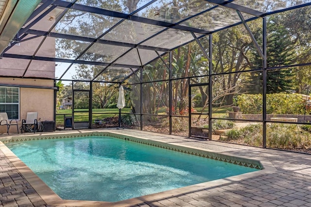 view of swimming pool featuring a patio area and glass enclosure