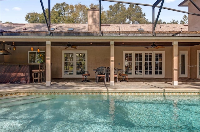 view of swimming pool with ceiling fan, exterior bar, and a patio