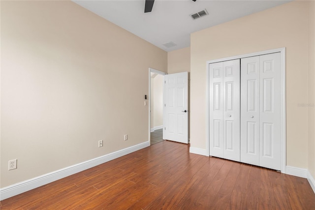 unfurnished bedroom featuring hardwood / wood-style floors, ceiling fan, and a closet