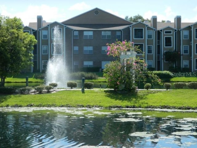 view of community with a water view and a lawn