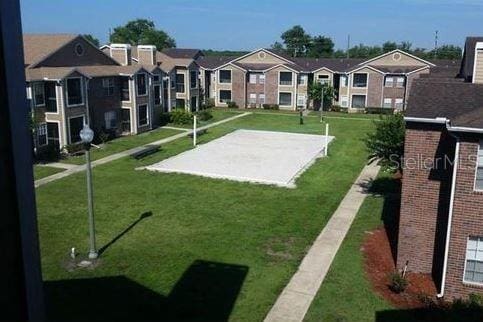 view of community with volleyball court and a lawn