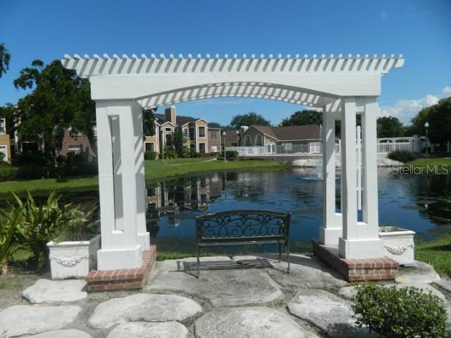 view of patio with a water view and a pergola