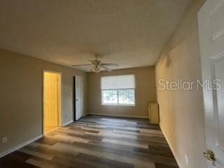 spare room featuring dark hardwood / wood-style flooring and ceiling fan