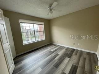 unfurnished bedroom featuring dark hardwood / wood-style flooring, a textured ceiling, and ceiling fan