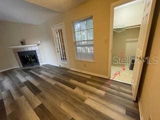 unfurnished living room with lofted ceiling, wood-type flooring, and a fireplace