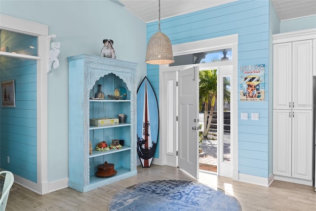 mudroom featuring light hardwood / wood-style floors and wood walls