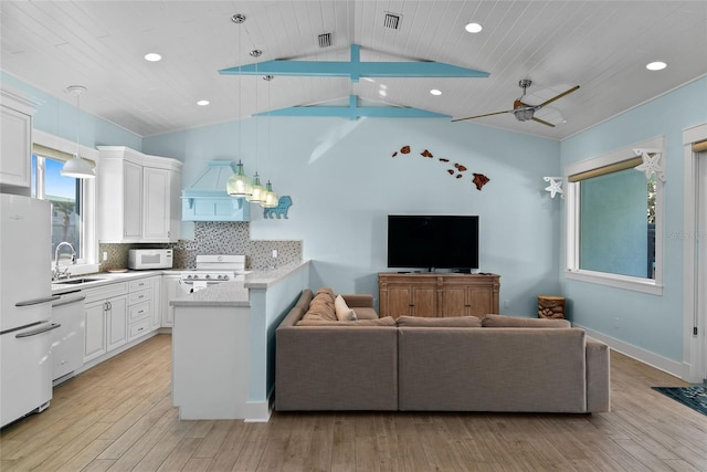 living room featuring sink, vaulted ceiling with beams, ceiling fan, and light hardwood / wood-style flooring