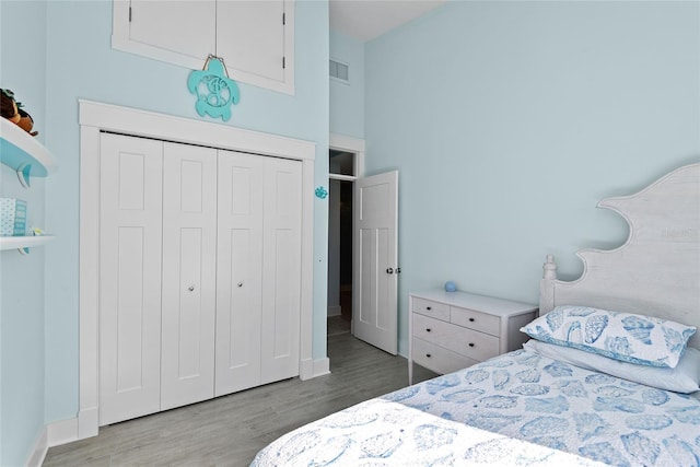 bedroom featuring a closet, a high ceiling, and light wood-type flooring