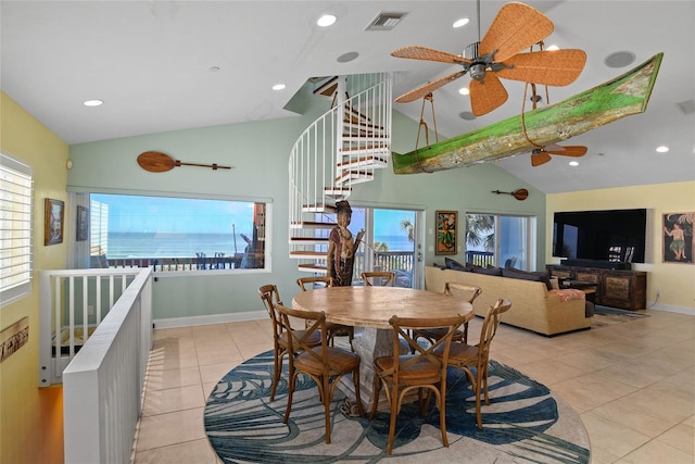 tiled dining space with a water view, ceiling fan, and high vaulted ceiling