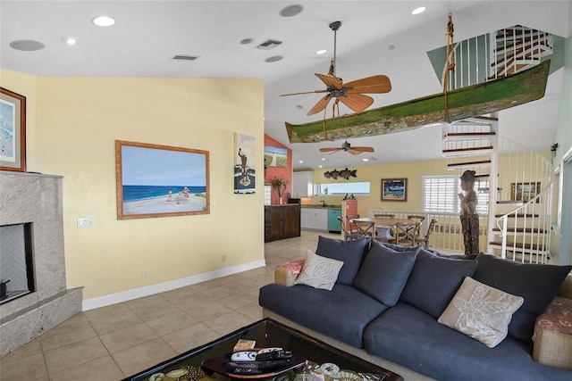 living room featuring light tile patterned floors, a high end fireplace, high vaulted ceiling, and ceiling fan