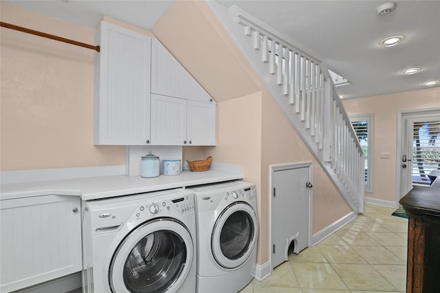 washroom with cabinets, washer and dryer, and light tile patterned flooring