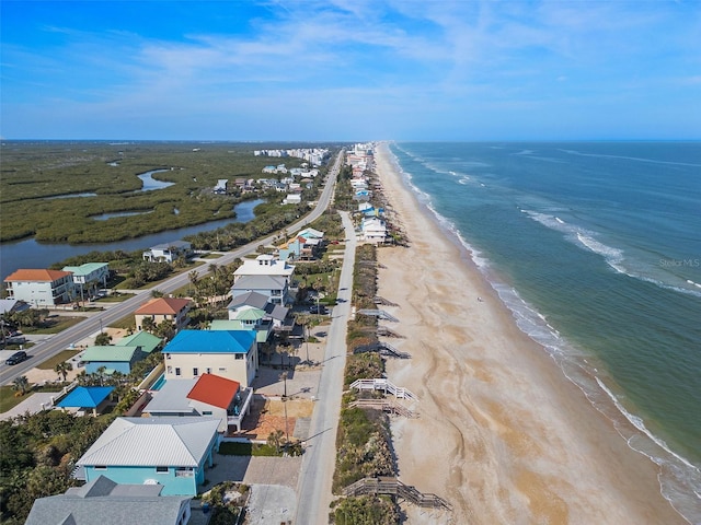 bird's eye view with a water view and a beach view