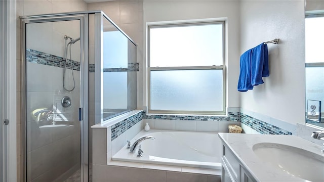 bathroom featuring shower with separate bathtub, a wealth of natural light, and vanity