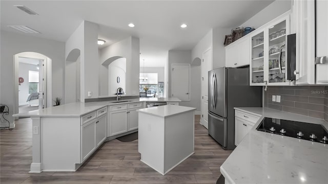 kitchen featuring a center island, sink, kitchen peninsula, and white cabinets