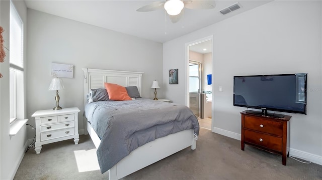 bedroom with dark colored carpet, ceiling fan, and ensuite bath